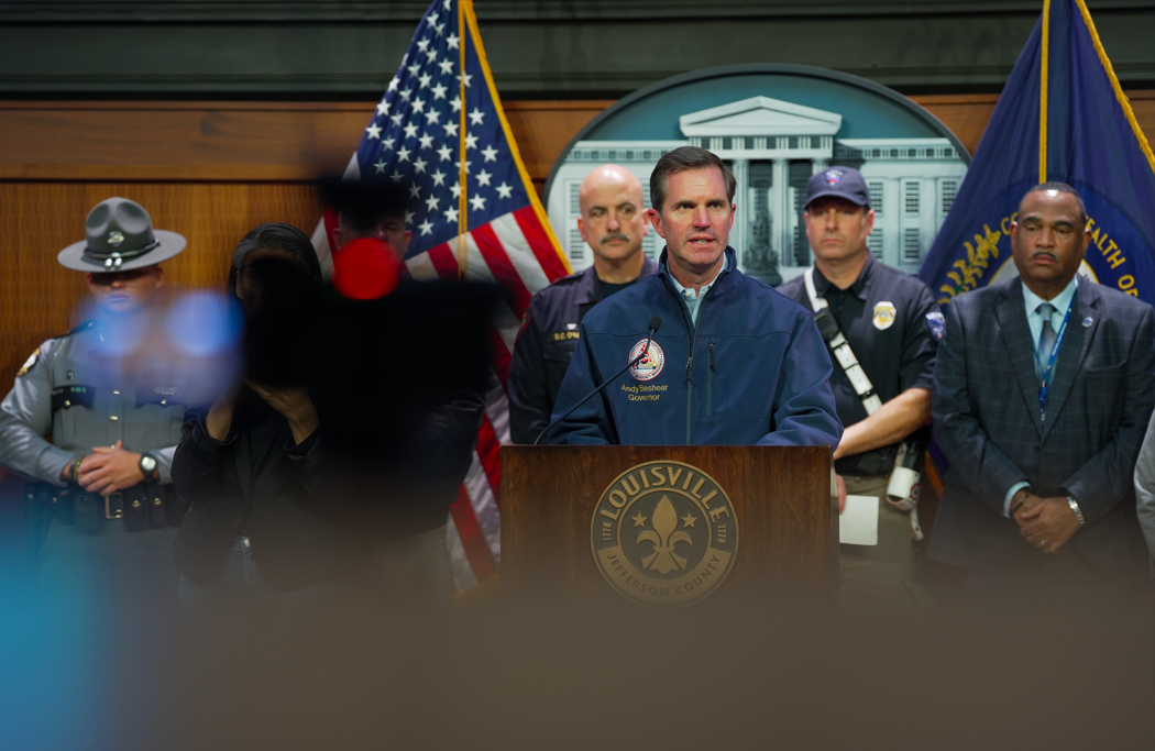 Kentucky Governor Andy Beshear behind a podium at a press conference